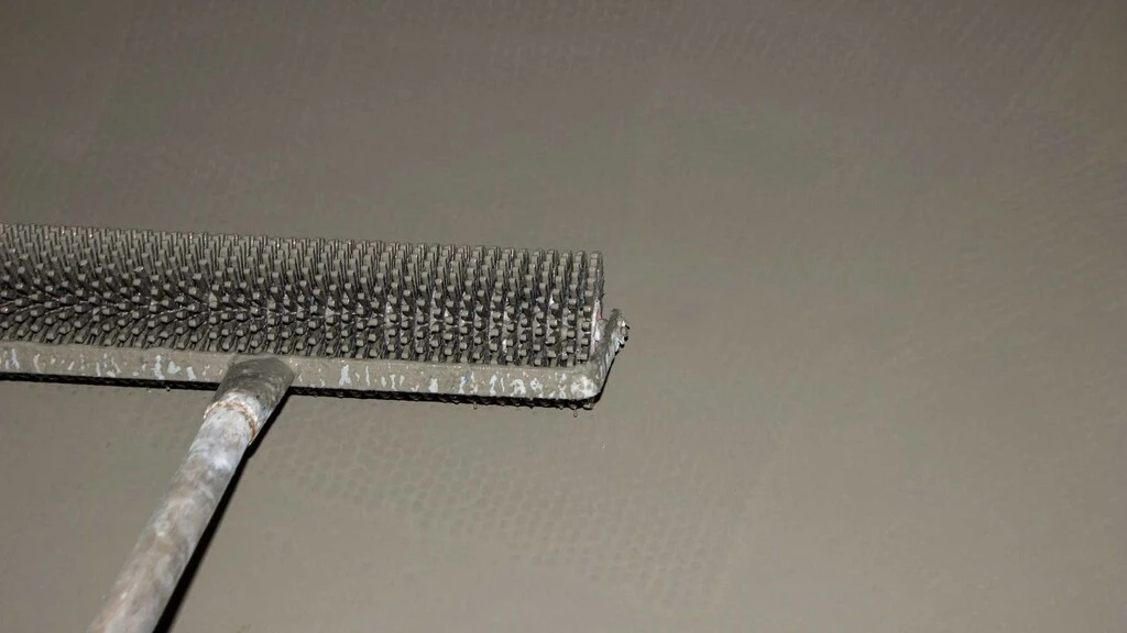 Praskanie bublín v nivelitovej podlahe pomocou valčeka