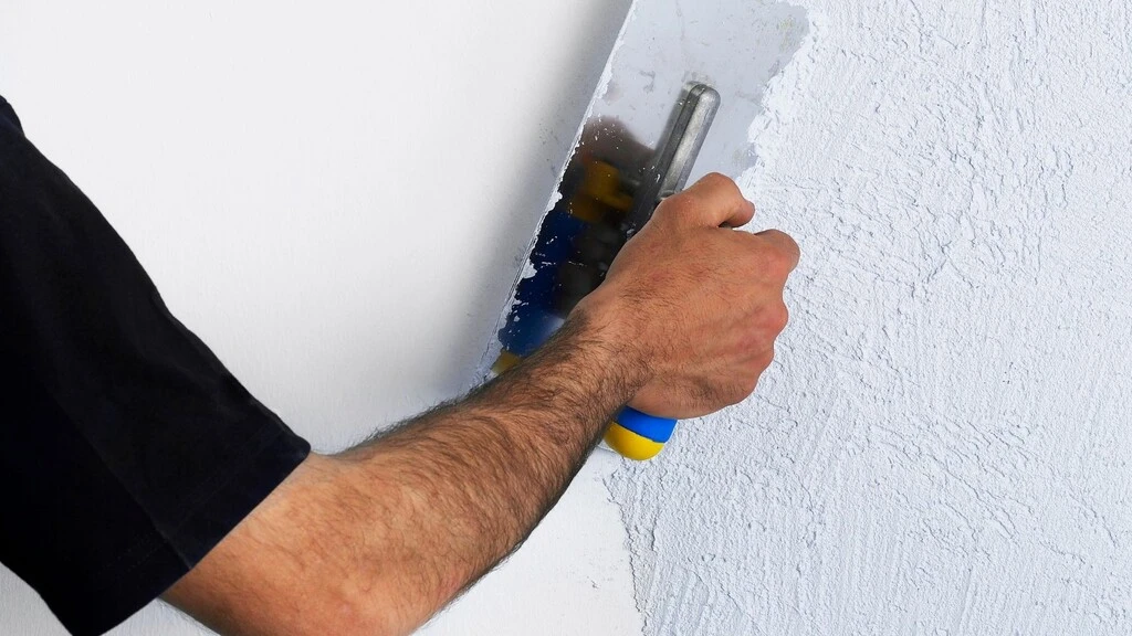 ruka s čiernym rukávom so stierkou