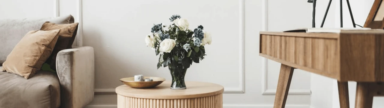 Homestaging obývačky pomocou dizajnových doplnkov a kytice ruží.