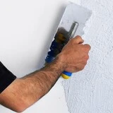 Nahadzovanie novej omietky hladidlom oprava poškodenej fasády