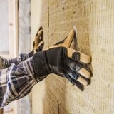 muž v šiltovke s rukavicami, ktorý zatepluje