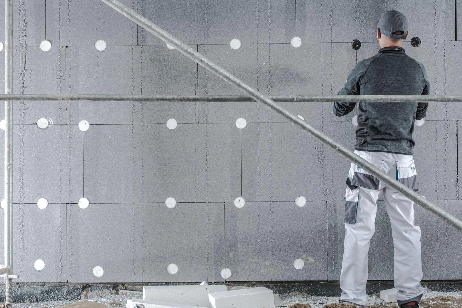 Vkladanie kotiev medzi jednotlivé panely zateplenia.