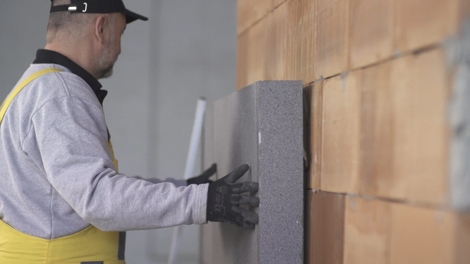 Lepenie šedého polystyrénu ako izolantu zateplenia.