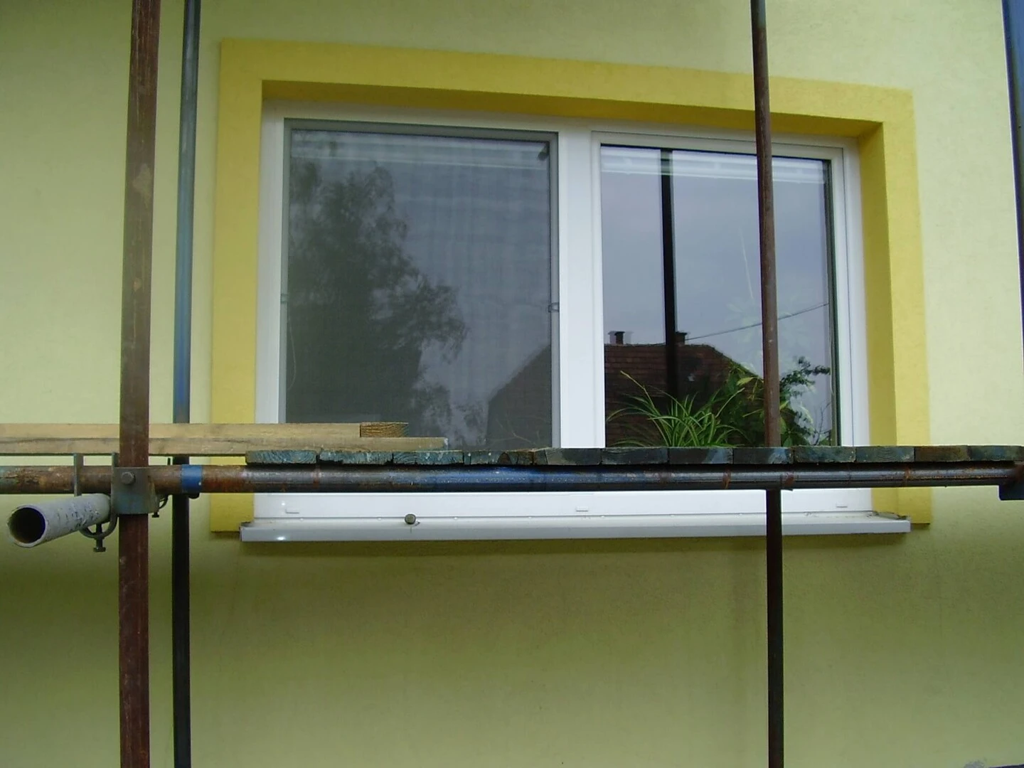 Lešenie postavené pri okne domu