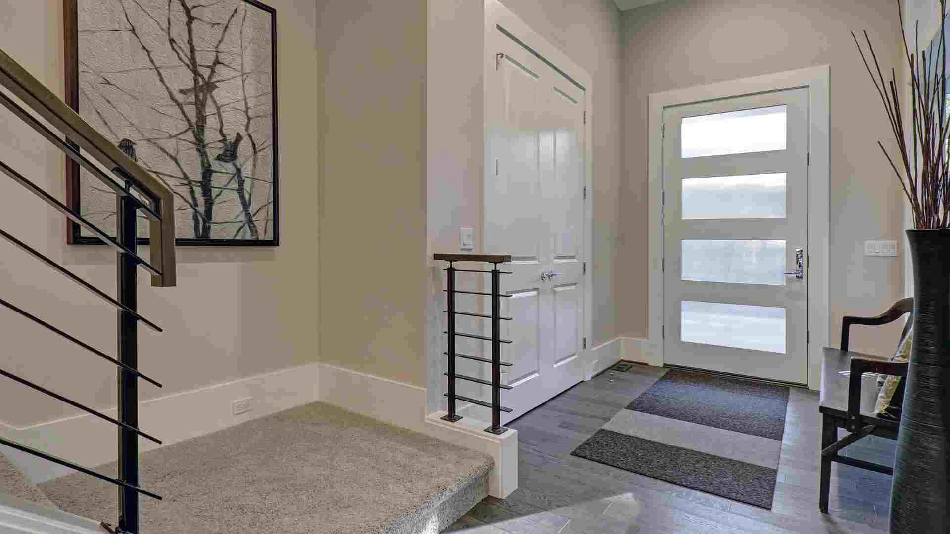 Chodba s bielymi stenami, schodmi a čiernym zábradlím