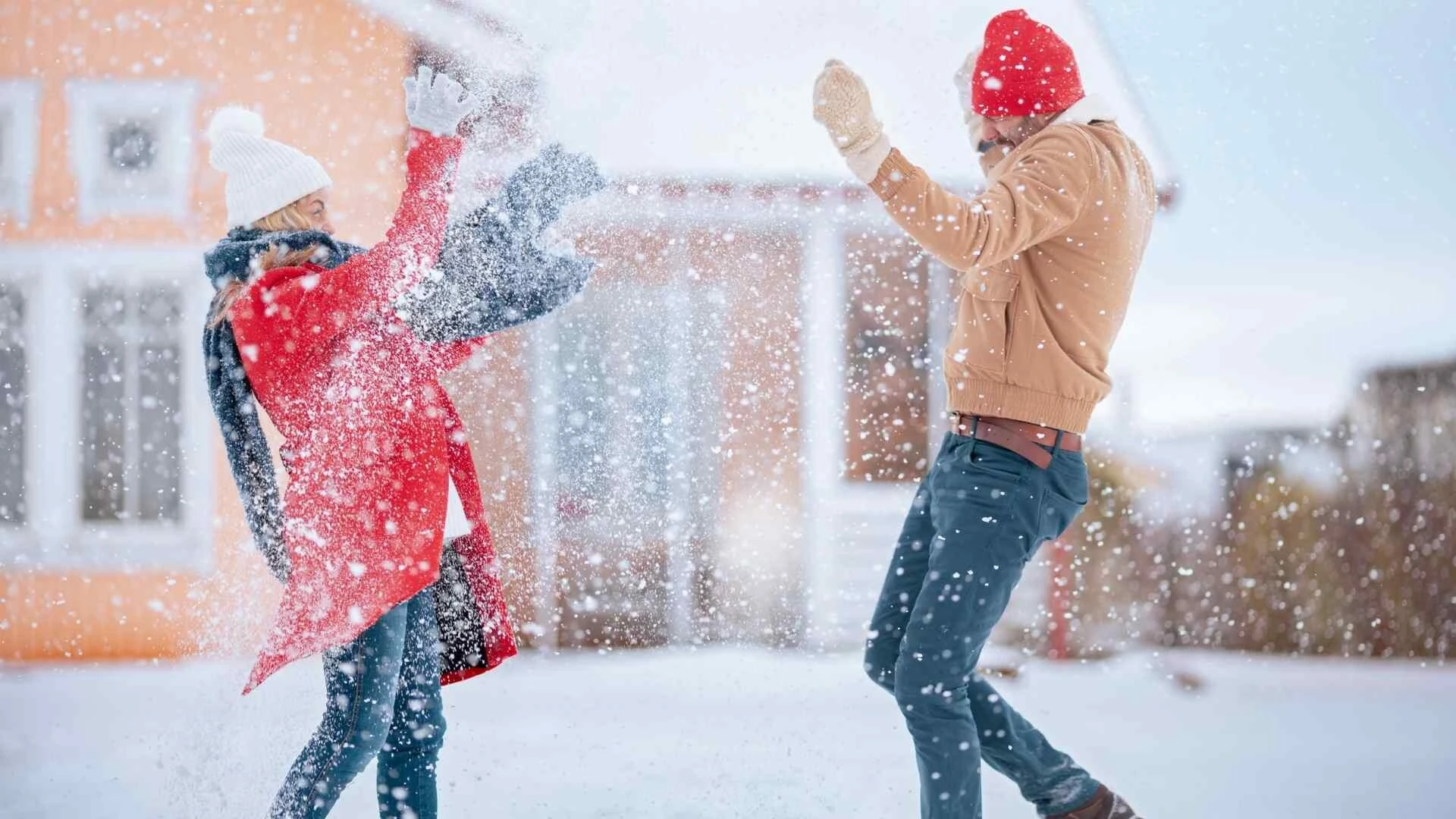 Guľovanie v zime pred domom s oranžovou fasádou