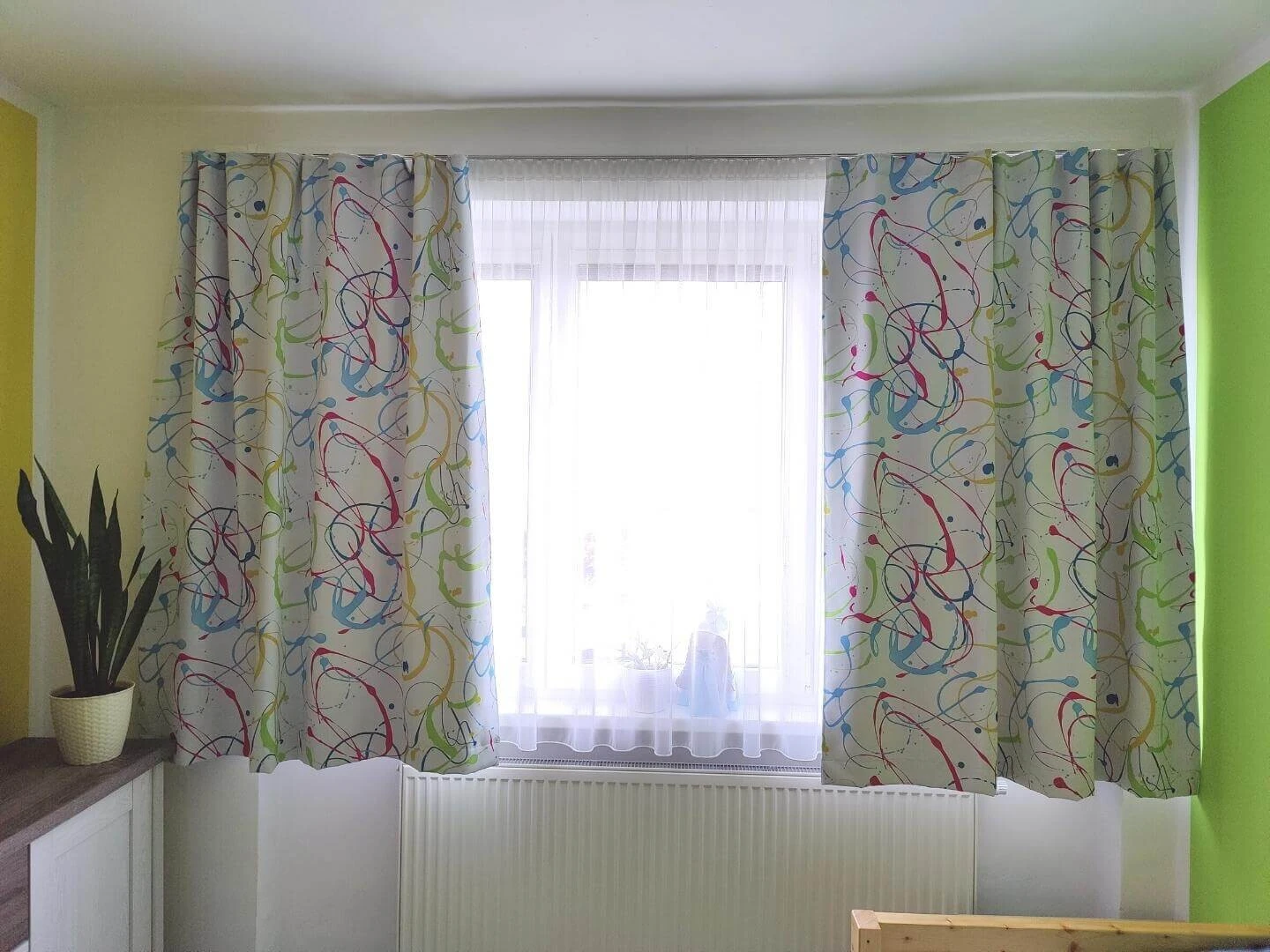 Závesy s farebným vzorom a záclona na okne v detskej izbe
