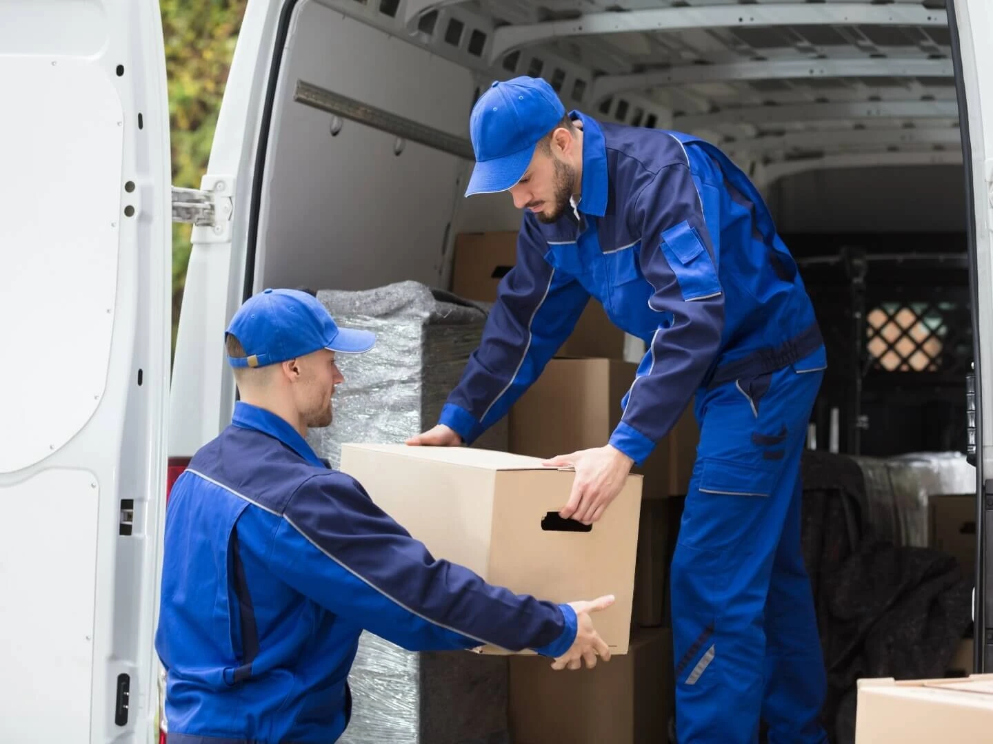 Pracovníci sťahovacej firmy nakladajúci krabice do dodávky