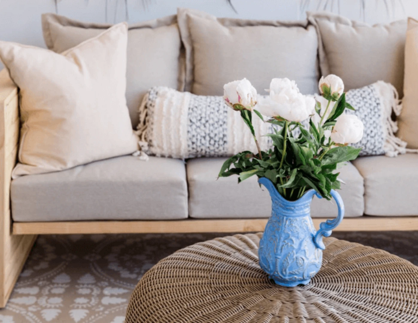 Čerstvá kytica pivónií v modrej ozdobnej váze v obývačke.