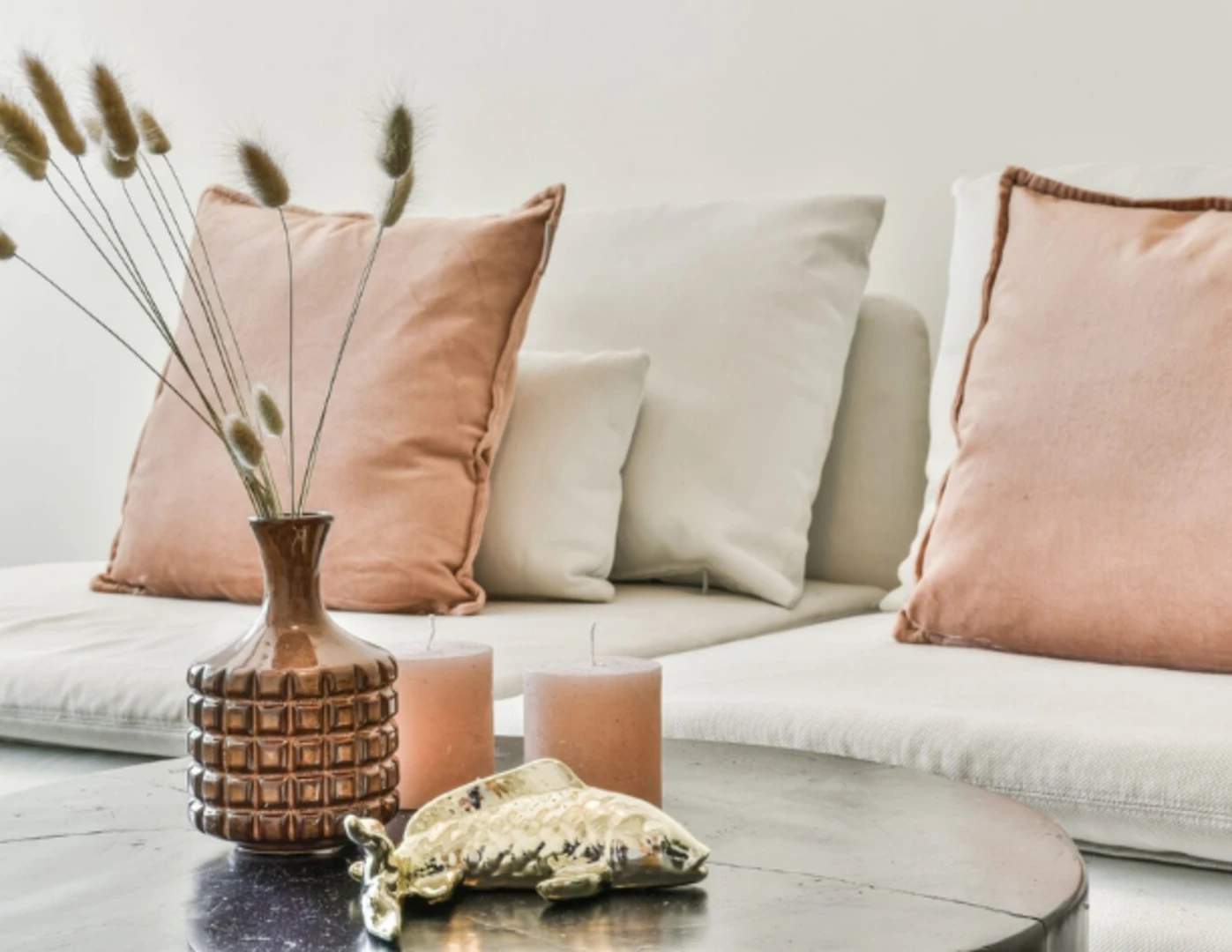 Sviečky a iné dekorácie v obývačke v prírodných farbách.