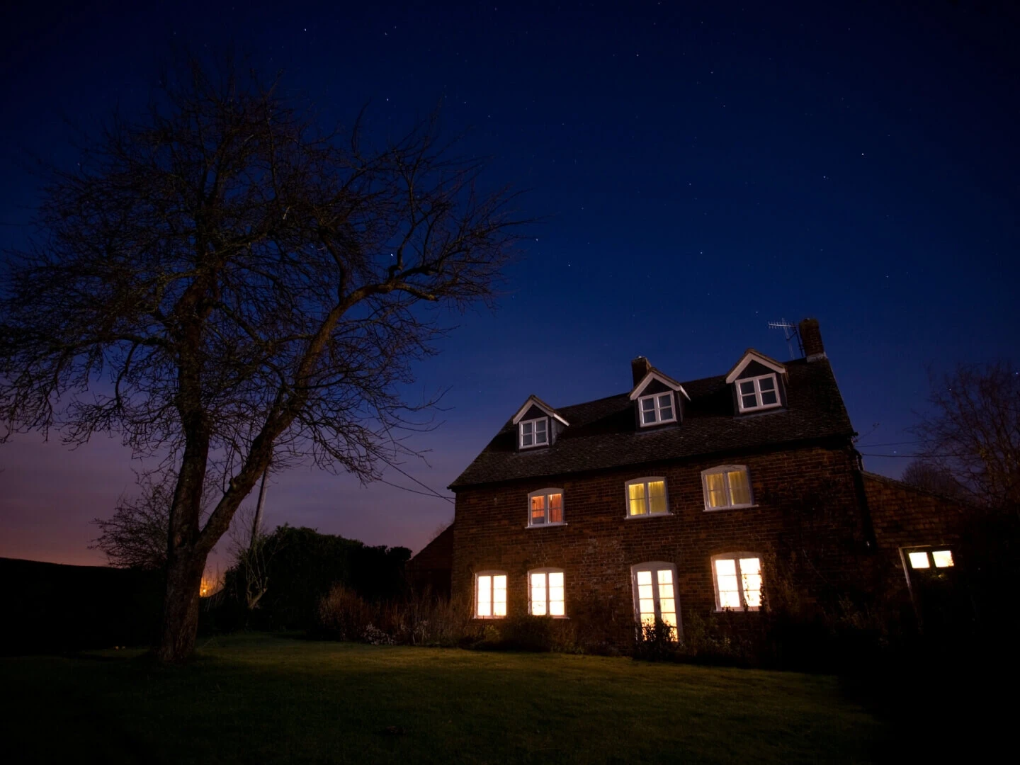 Zasvietené svetlá v dome počas noci.
