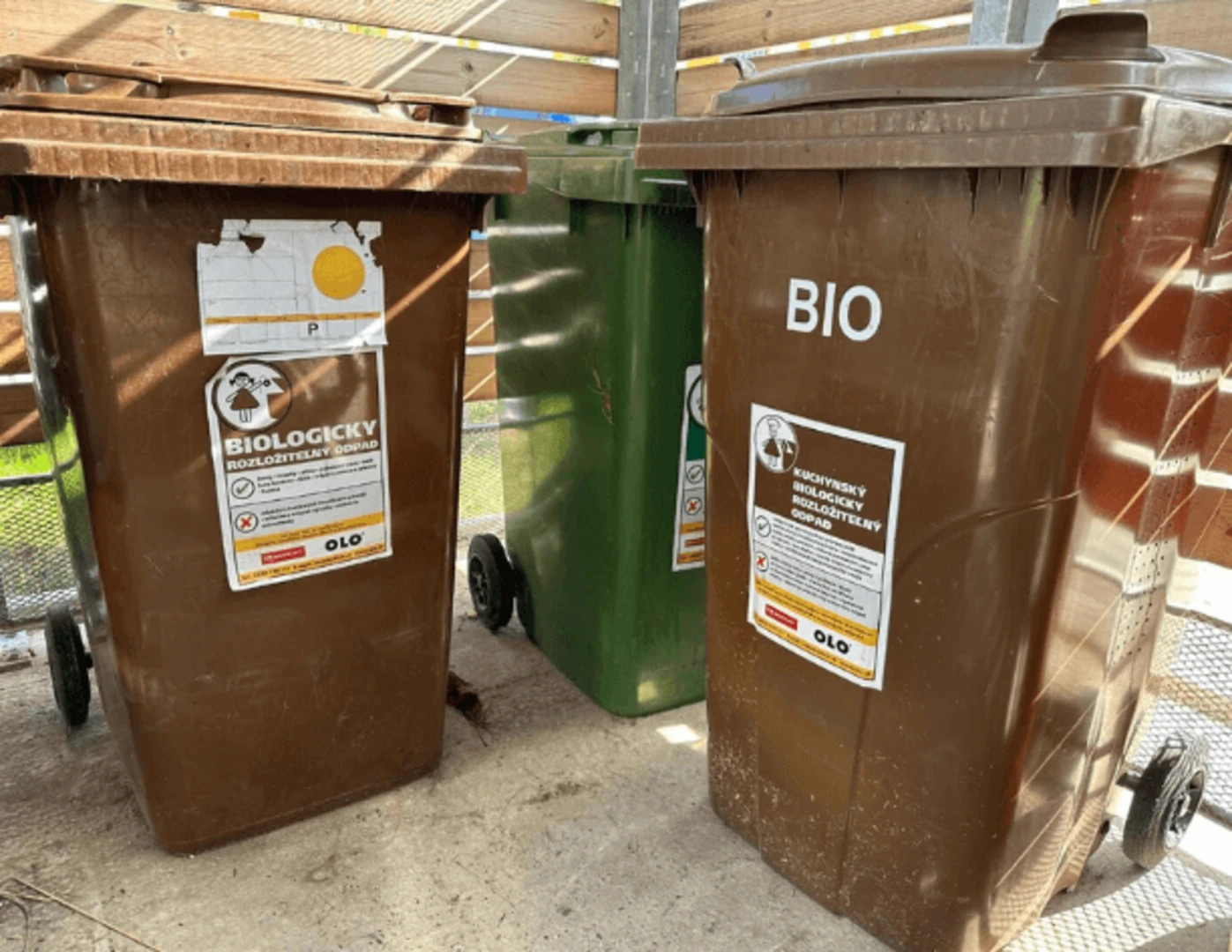 Hnedé nádoby OLO v kontajnerovom stojisku bytového domu.