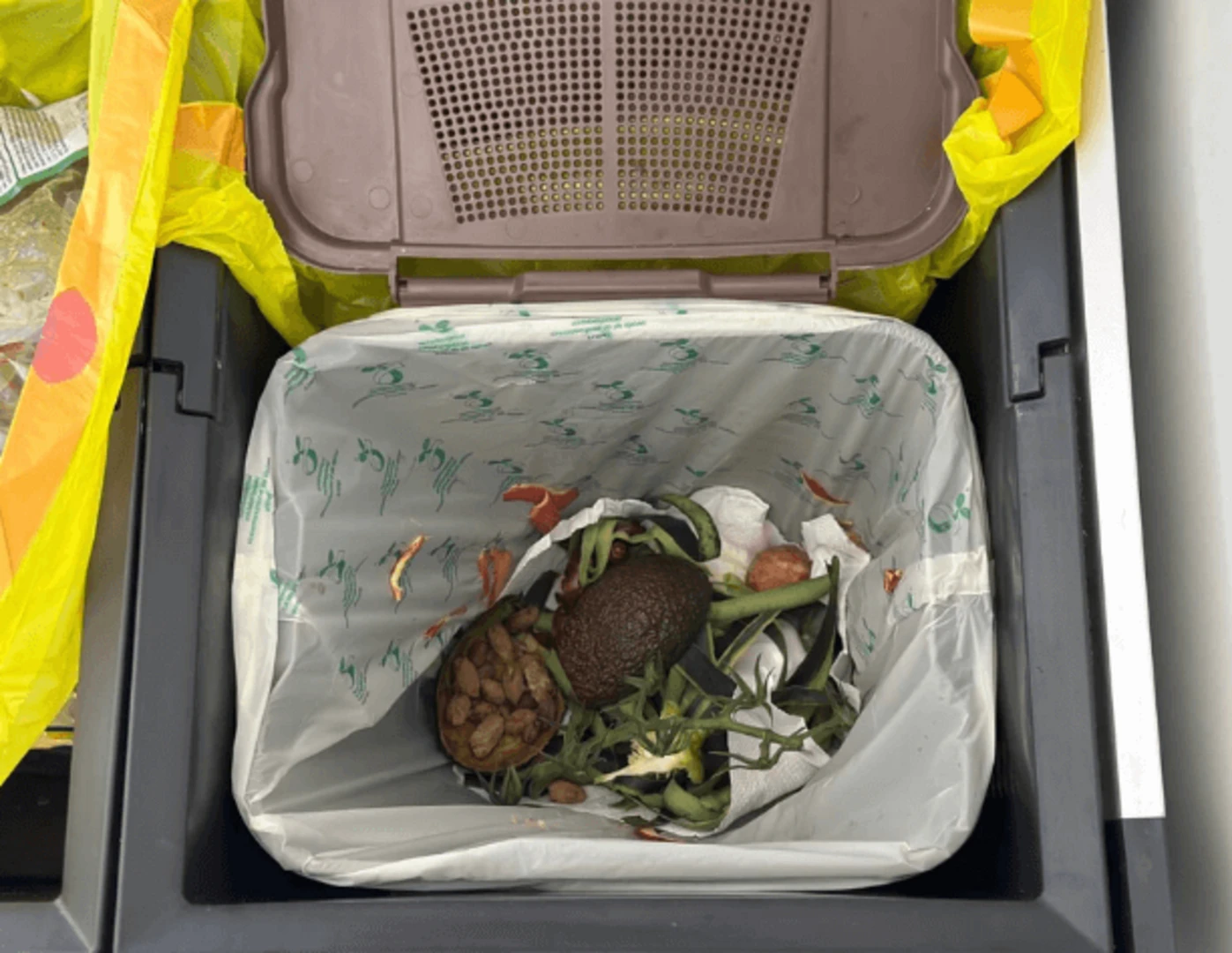 Zvyšky jedál v nádobe na kompost v byte.