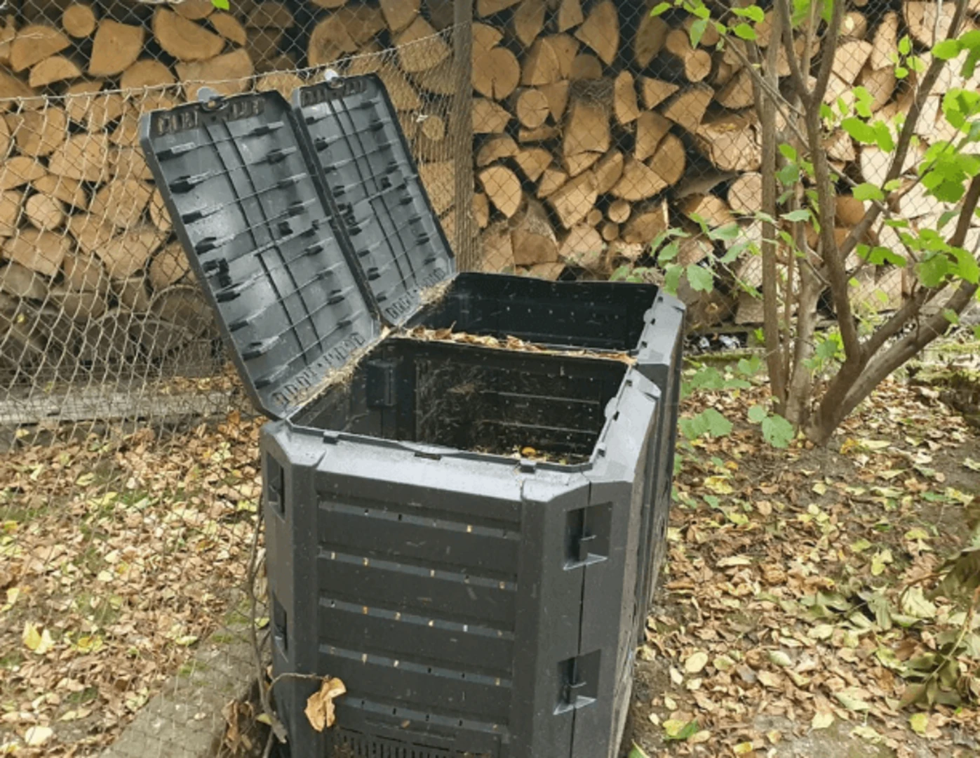 Otvorené veľké nádoby na kompost na záhrade.