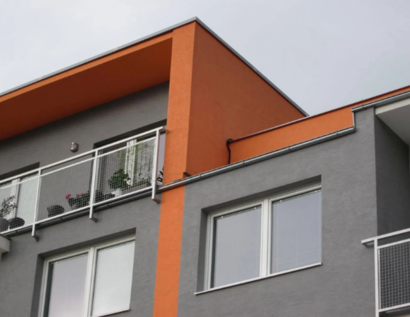 Šedo-oranžová silikónová omietka na bytovom dome Staré Grunty.
