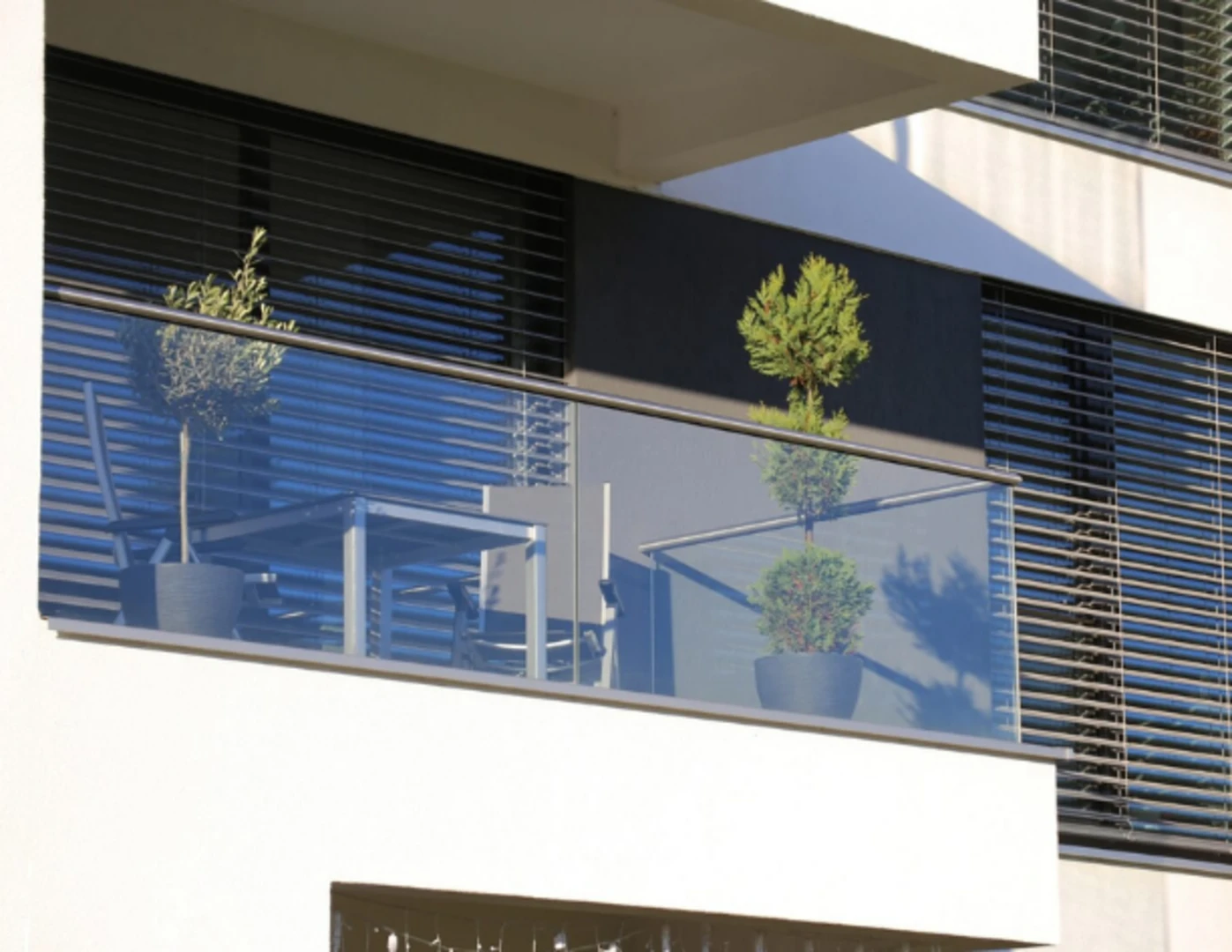 Moderný presklený balkón s rastlinami v kvetináči.