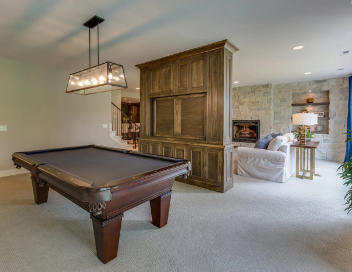 Zrekonštruovaná pivnica na herňu s billiardovým stolom a rekreačným priestorom s gaučom.