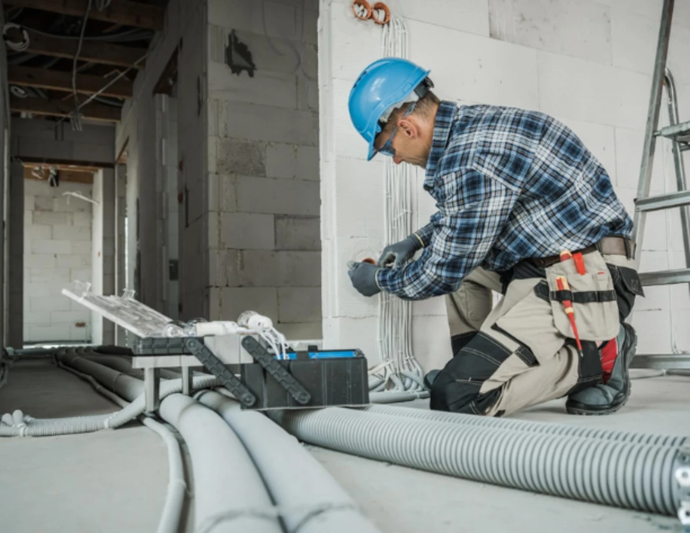 Elektrikár vykonáva elektroinštaláciu pri rekonštrukcii priestorov.