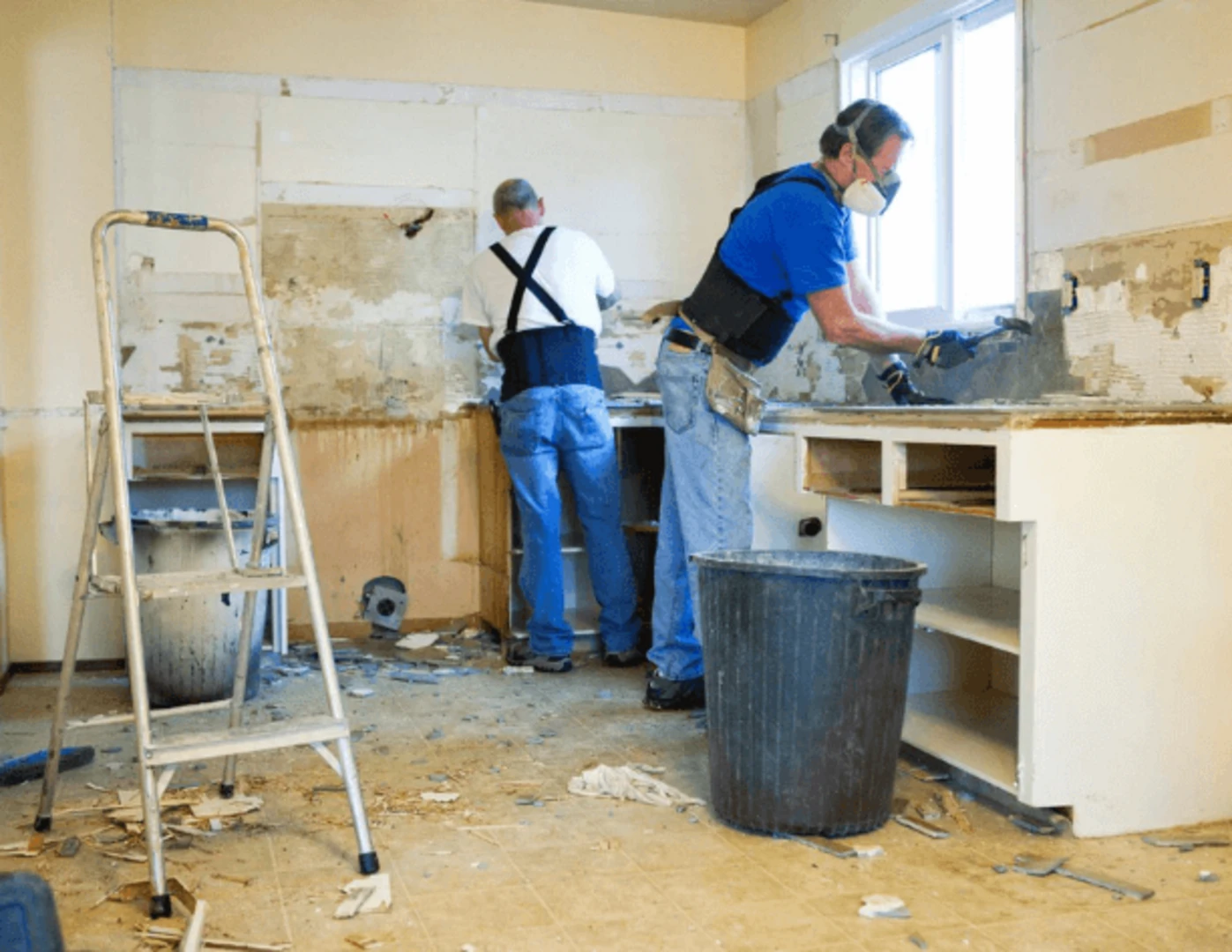 Pracovníci odstraňujú starú kuchyňu v procese renovácie.