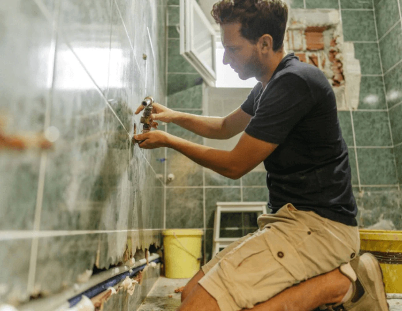 Muž svojpojmocne renovujúci kúpeľnu.