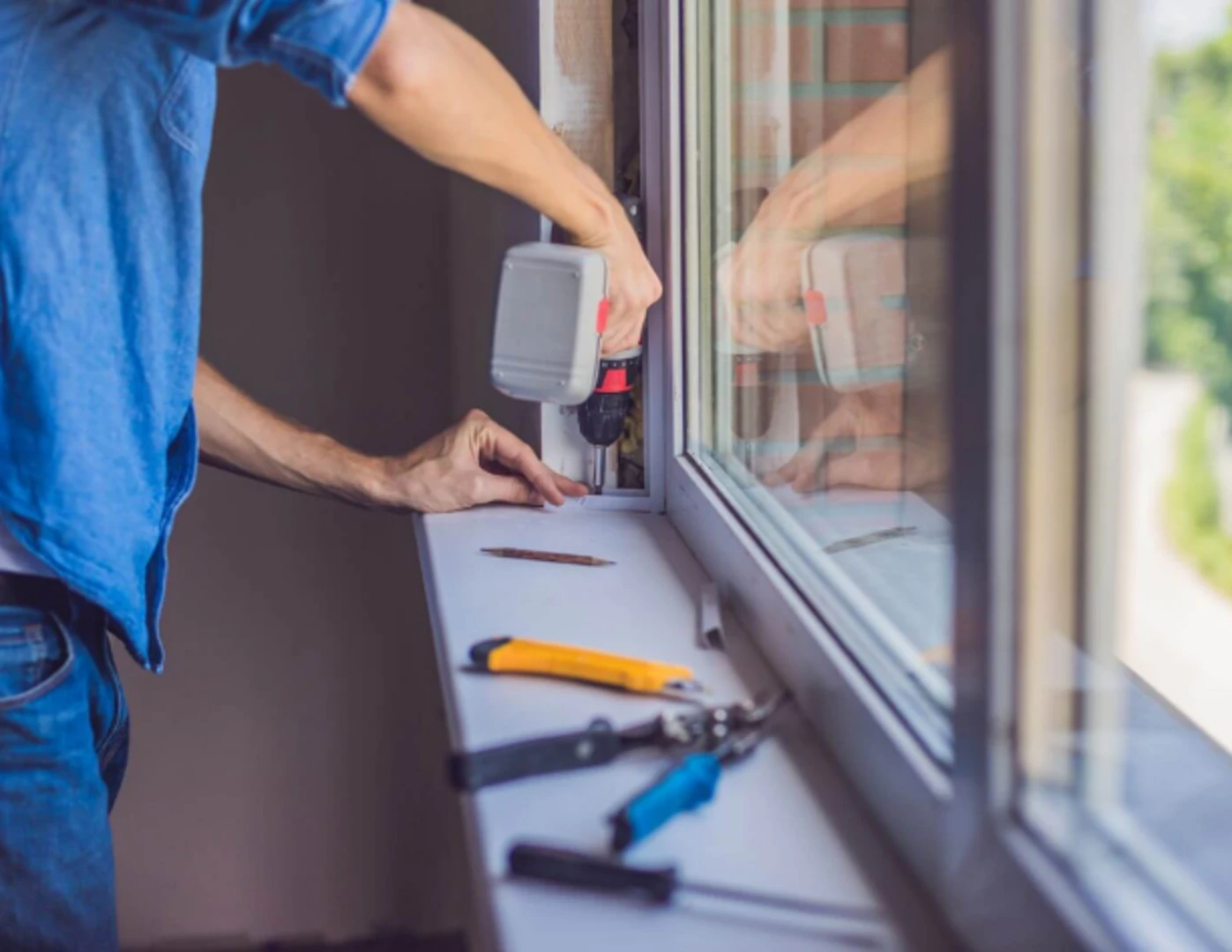 Muž inštaluje nové  okná.