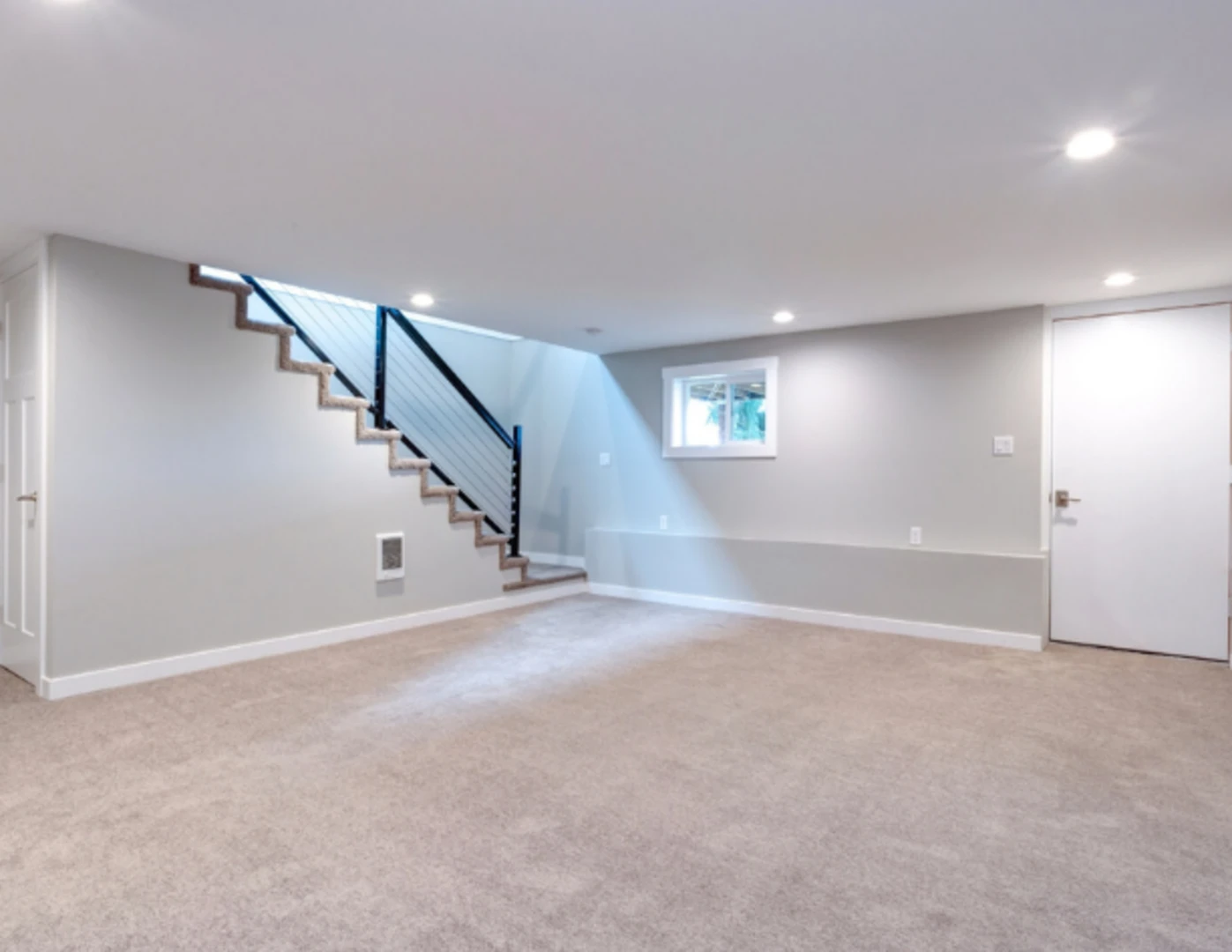 Zrekonštruovaná pivnica s oknom, osvetlená bodovými svetlami v strope.