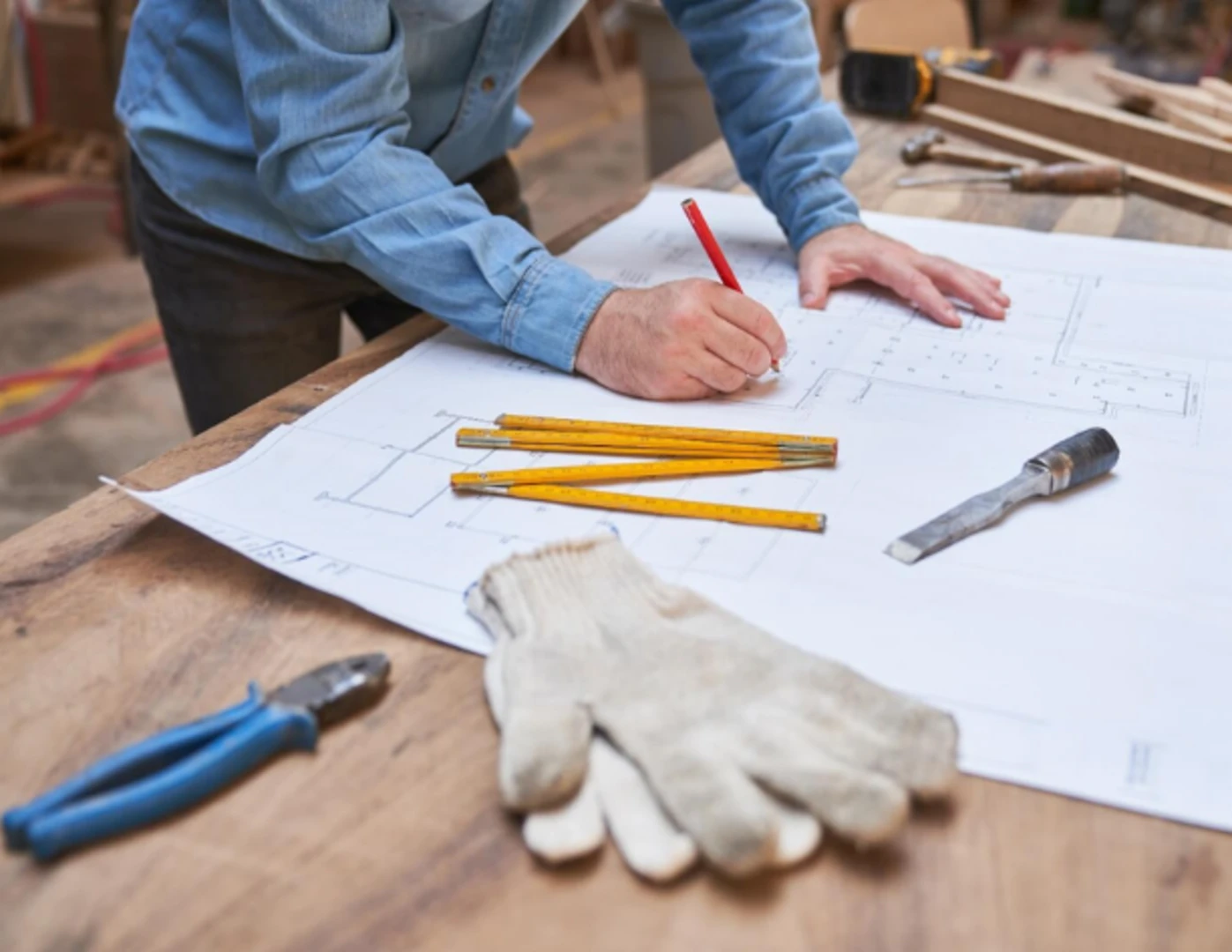 Architekt kreslí pôdorys a plán rekonštrukcie.