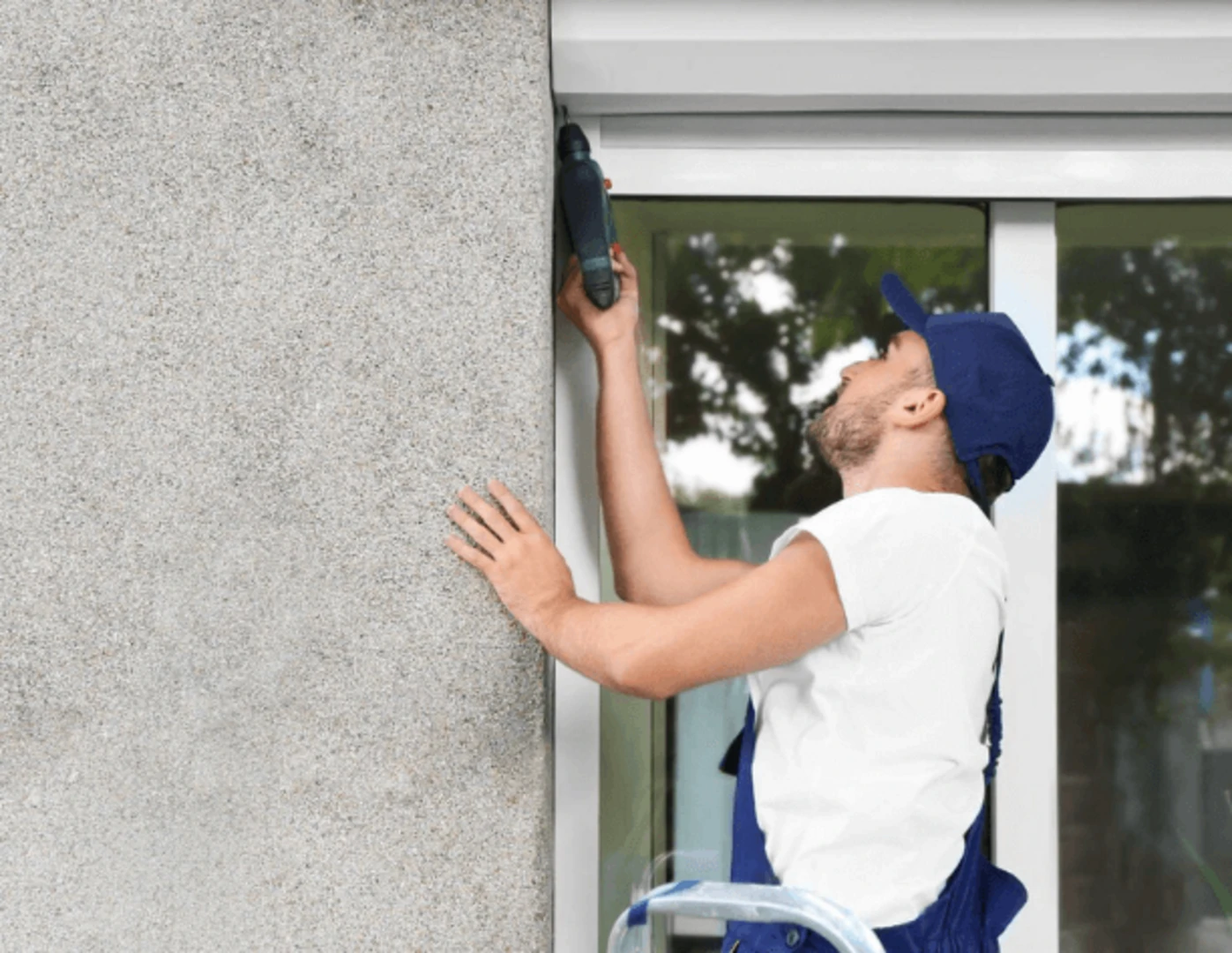 Muž inštalujúci exteriérové rolety na okná bytu.