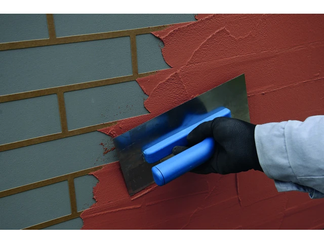 Nanášanie dekoratívnej omietky na šablónu hladidlom