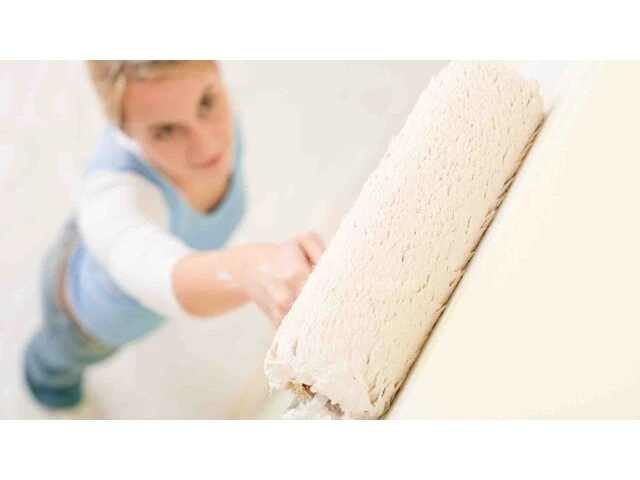 Žena aplikujúca vnútorné a vonkajšie nátery valčekom