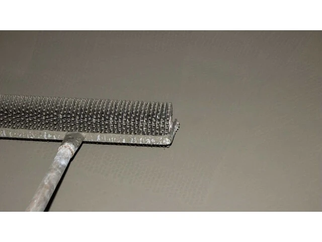 Praskanie bublín v nivelitovej podlahe pomocou valčeka