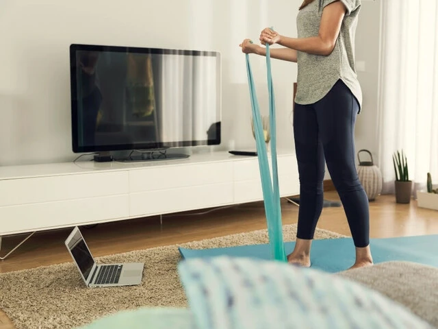 Žena cvičí doma podľa videa z notebooku