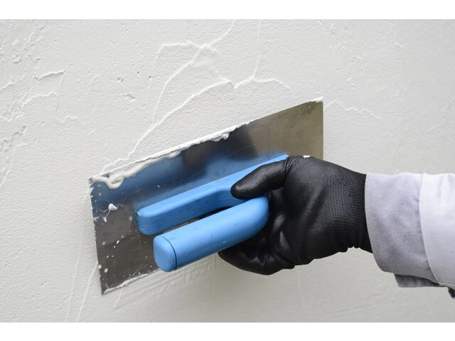 Nanášanie druhej vrstvy omietky na stvrdnutý podklad