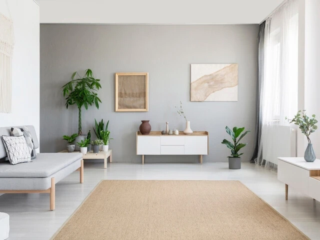 Obývačka so sedačkou umiestnenou oproti oknám a radiátoru