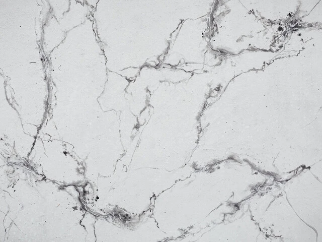 Bielo-šedá stena namaľovaná technikou mramorovania