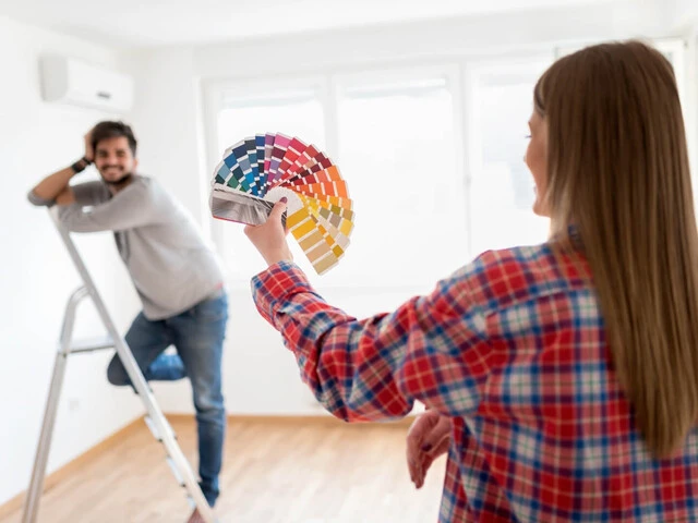 Mladý pár vyberajúci farbu steny podľa vzorkovníka