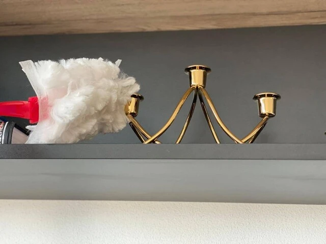 Utieranie prachu prachovkou zo zlatého svietnika