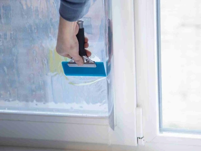 Inštalácia izolačnej okennej fólie stierkou