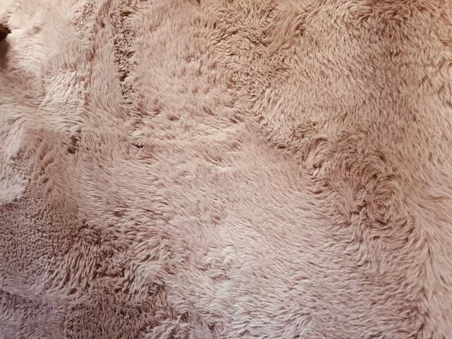 Mäkký syntetický koberec s vysokým vlasom.