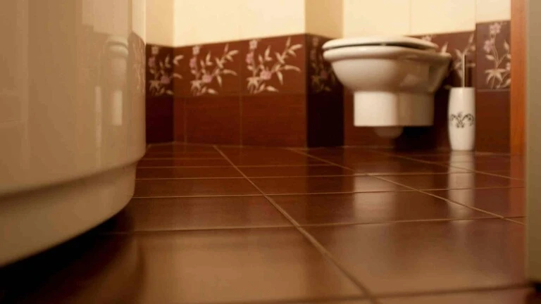 Hnedá podlaha v kúpeľni s toaletou a vaňou