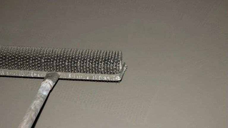 Praskanie bublín v nivelitovej podlahe pomocou valčeka