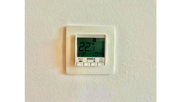 Termostat zobrazujúci teplotu 22,1 ºC.